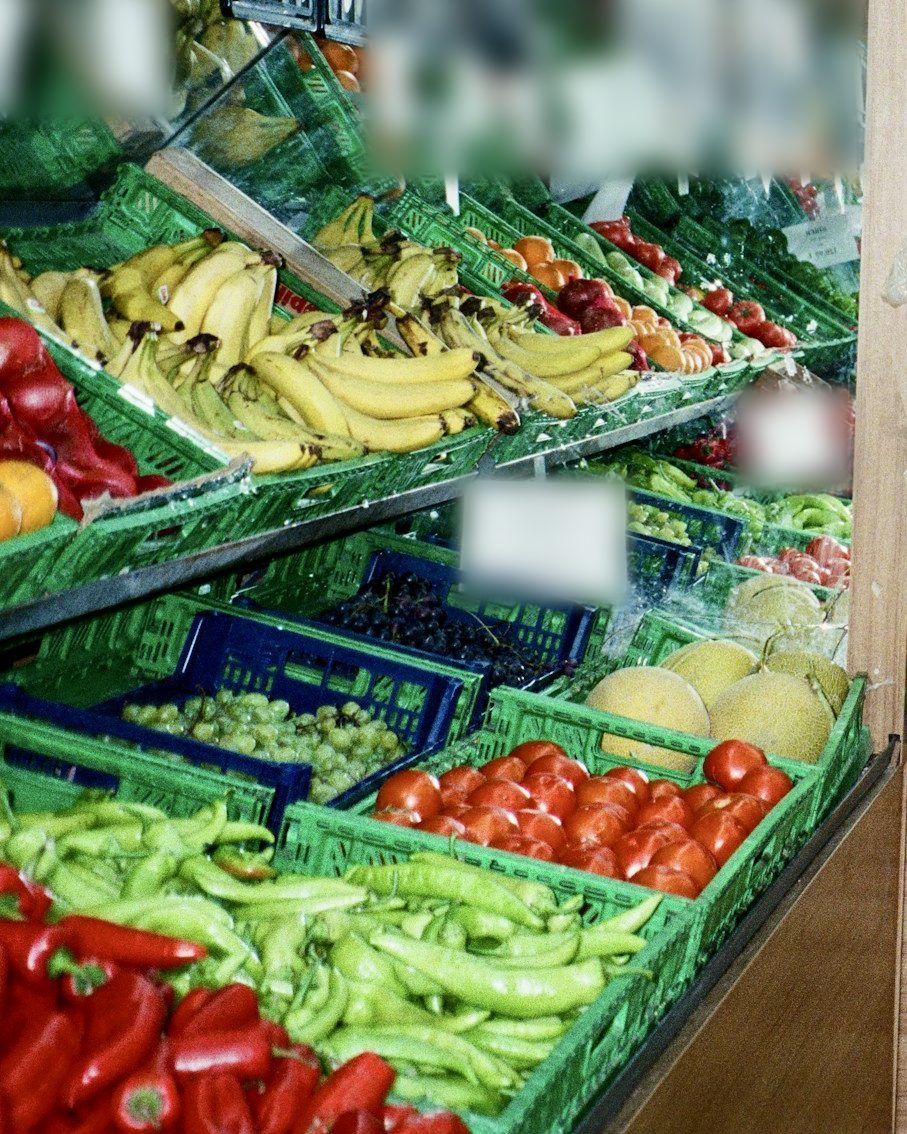 Moderne Website für einen Supermarkt, Beispielansicht: Obst- und Gemüseauslage in grünen Kisten mit Bananen, Tomaten, Honigmelonen, hellen Trauben, roten Paprika und hellgrünen Spitzpaprika